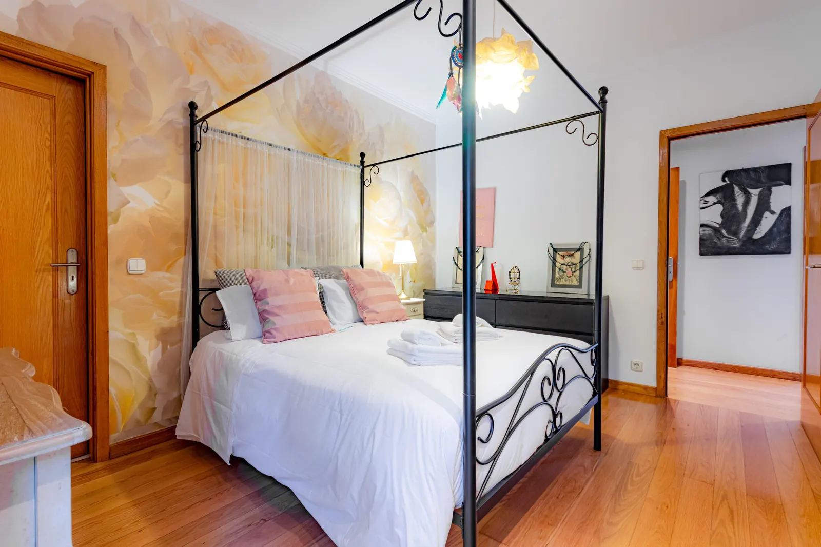 Bedroom with canopy bed and floral mural